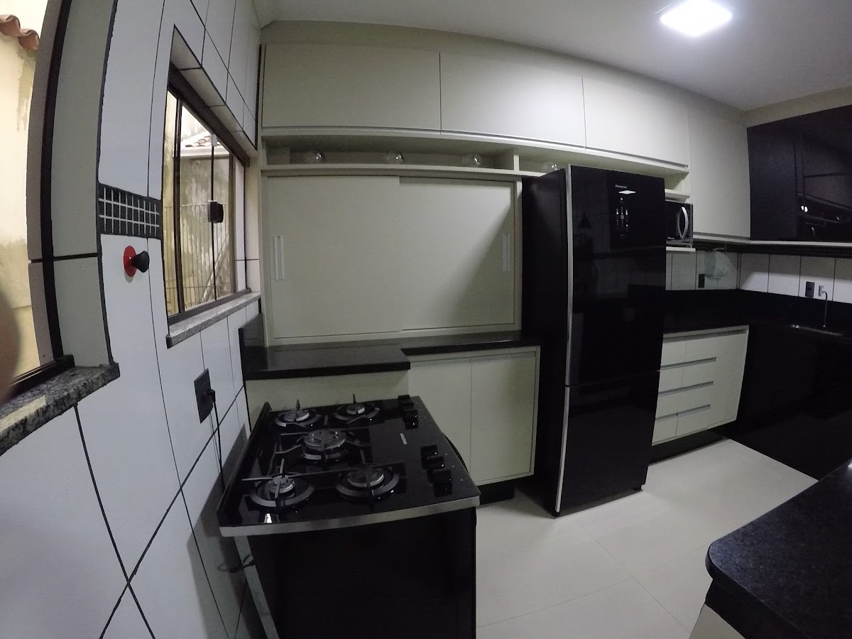 Cozinha planejada em tom off-white com bancada em granito